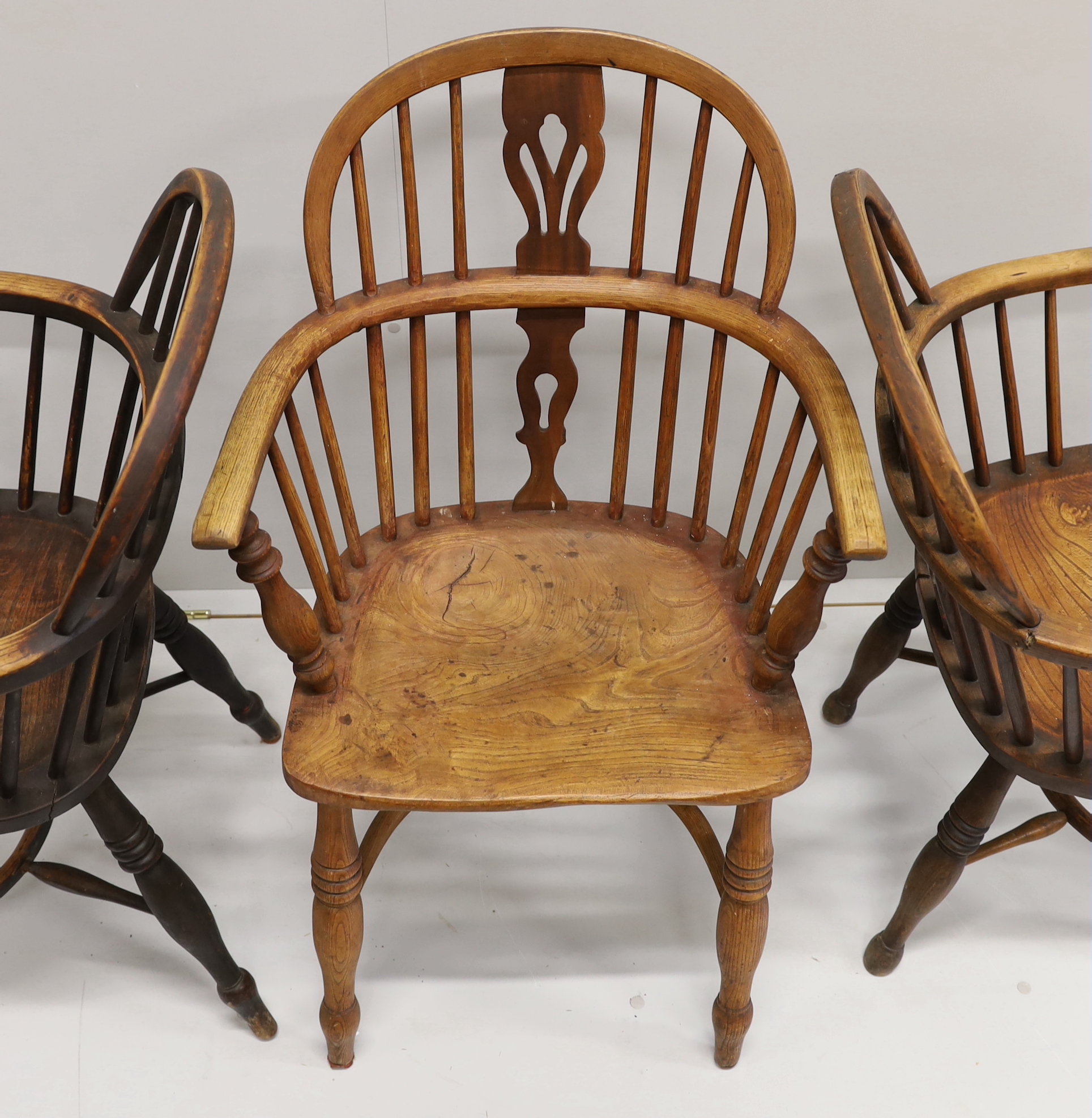 Three 19th century Nottingham area Windsor ash and elm elbow chairs with crinoline stretchers, largest width 55cm, depth 39cm, height 95cm